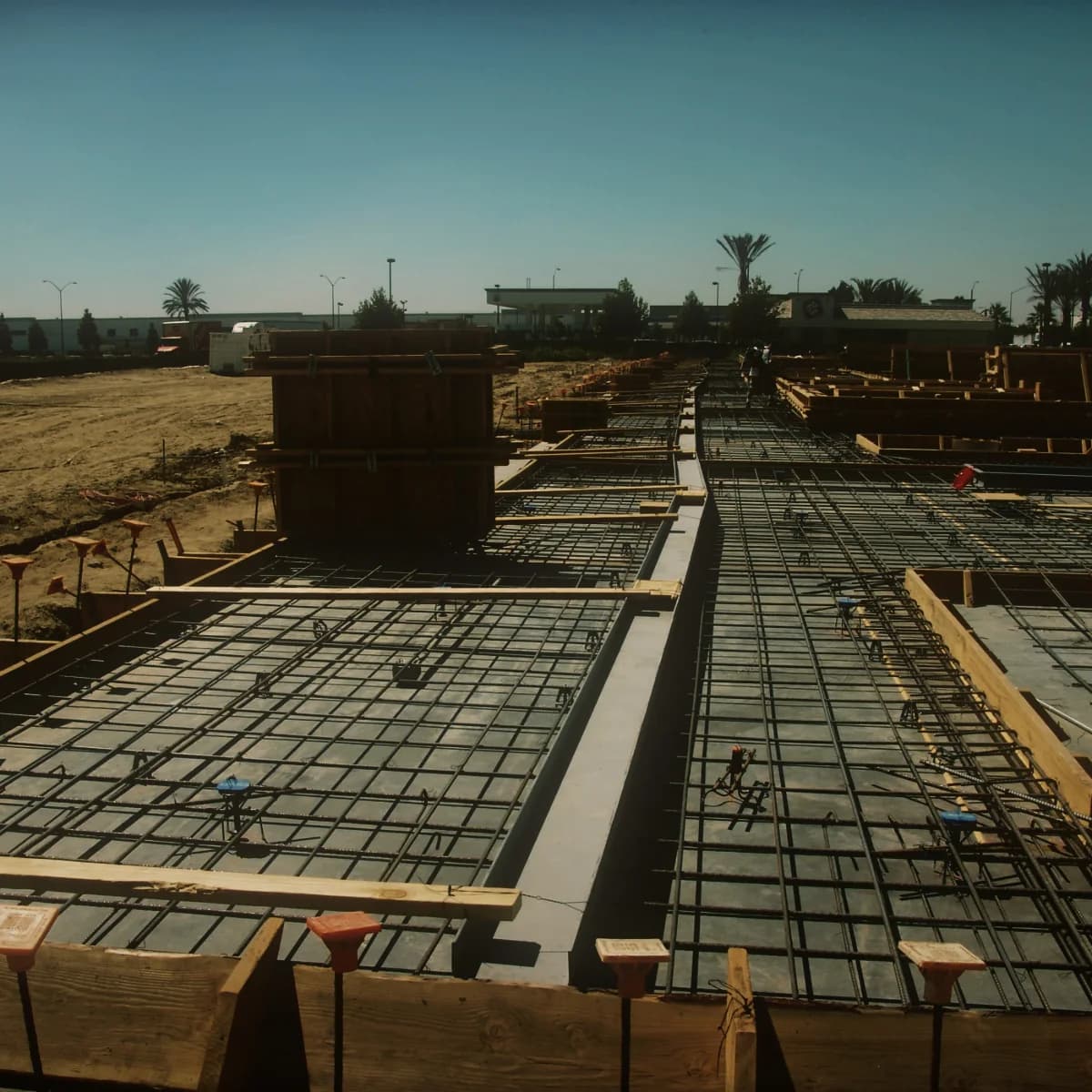 Timber formwork and reinforcing steel laid out across the full footprint of a floor slab before pouring
