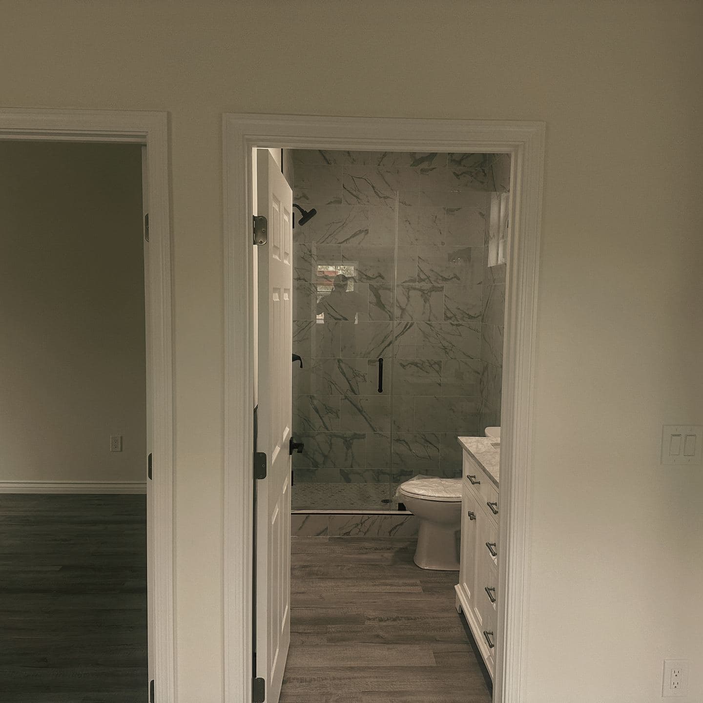 The empty main room of the Newbury Park accessory dwelling unit, with the bedroom doorway on one side and the tiled bathroom standing open on the other