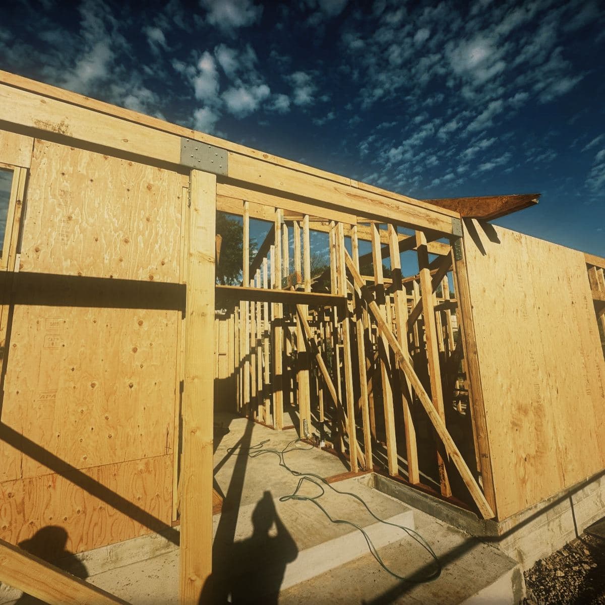 The completed timber frame of the guest house with its roof structure closed and the window openings formed
