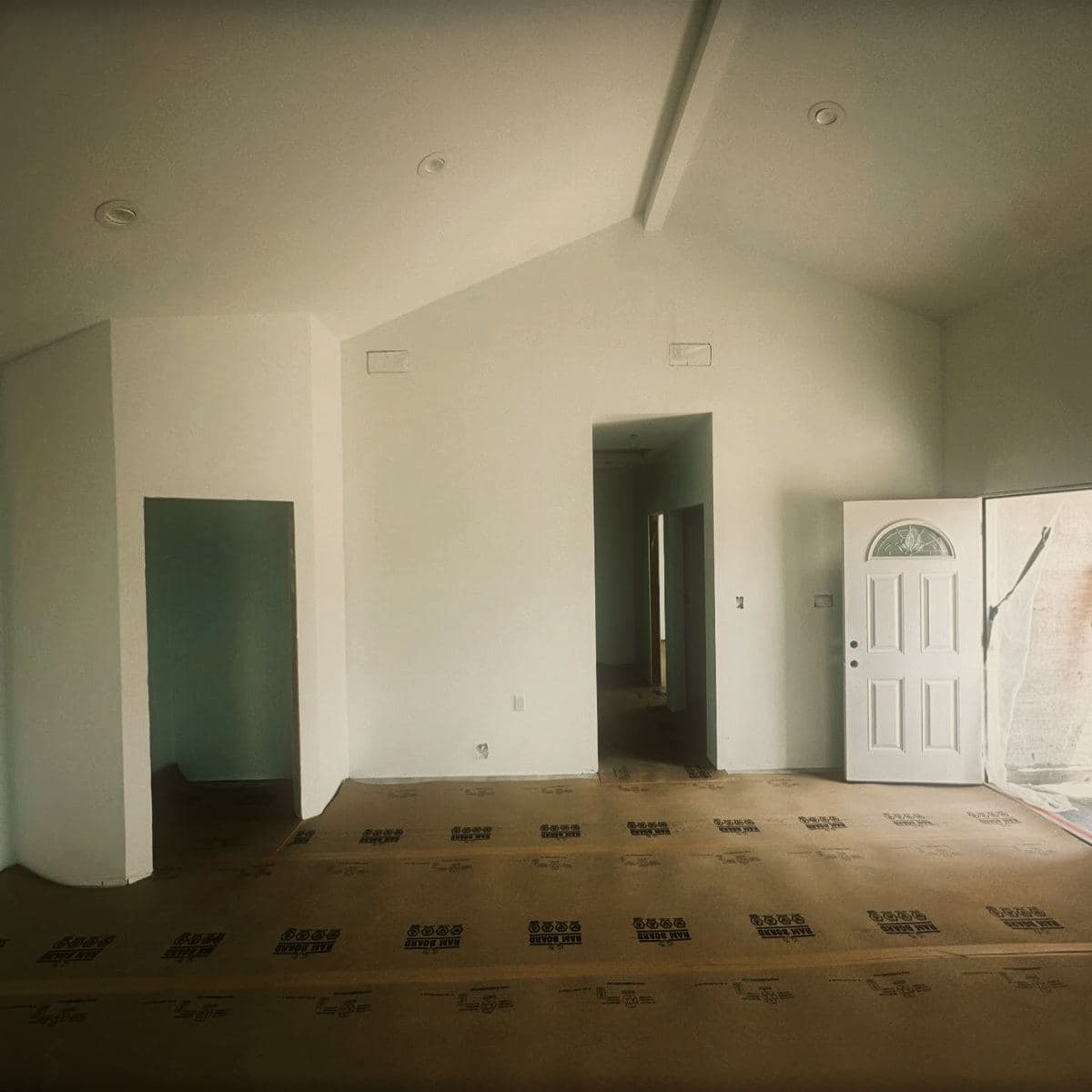 The finished living space of the guest house, the cathedral ceiling running its full length above plain white walls