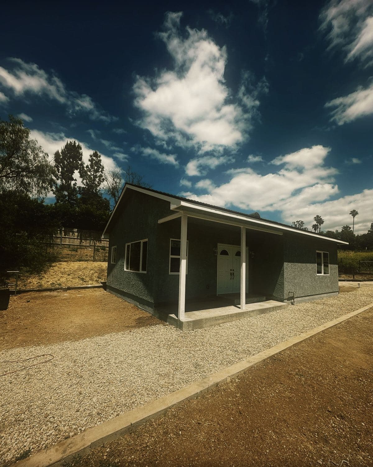 The completed detached guest house in Simi Valley, its covered porch and gable end seen from the driveway