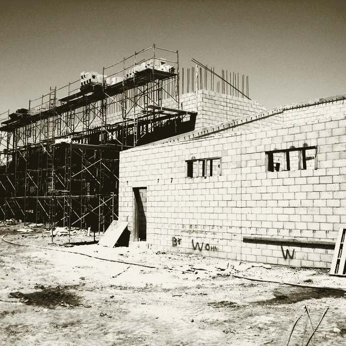 The science building under construction, block walls rising behind scaffolding